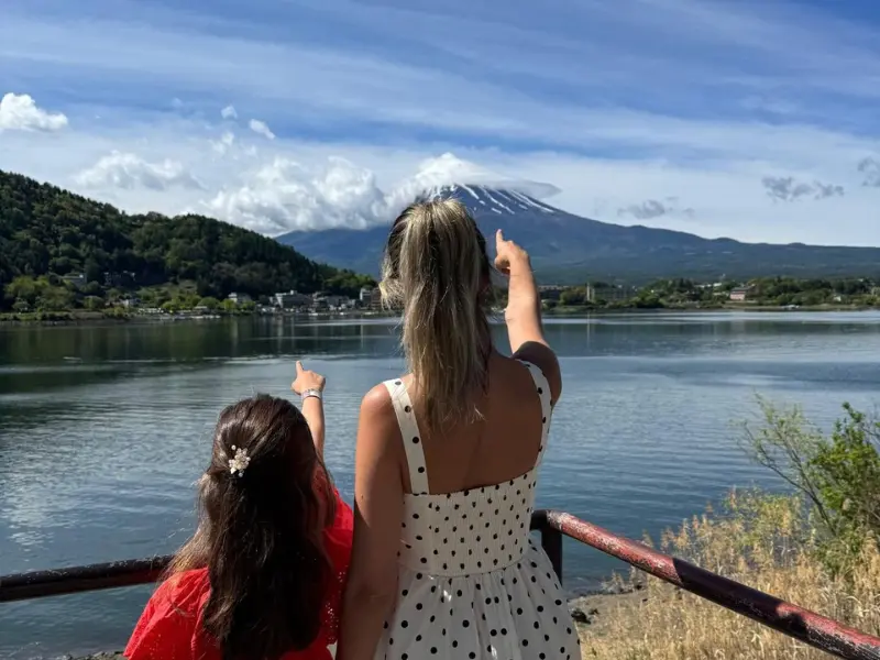 Mother and daughter pointing at Mount Fuji from Lake Kawaguchiko